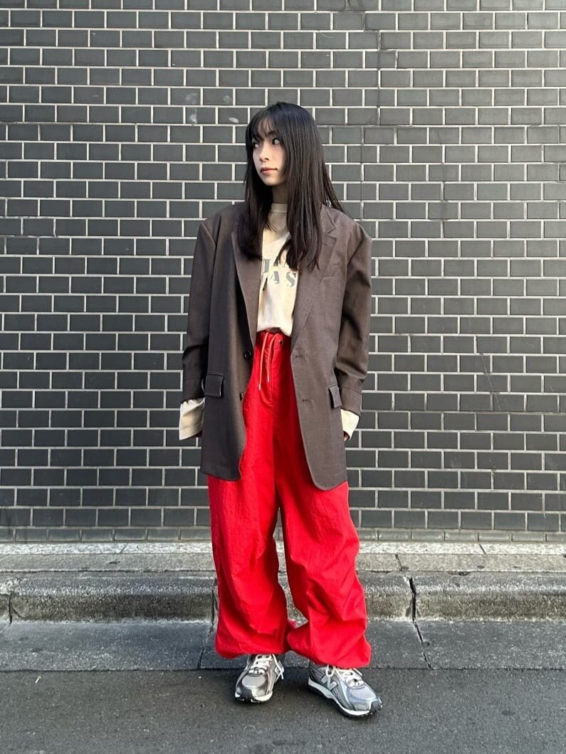 ブラウンのジャケットと赤いパンツを着た女性
