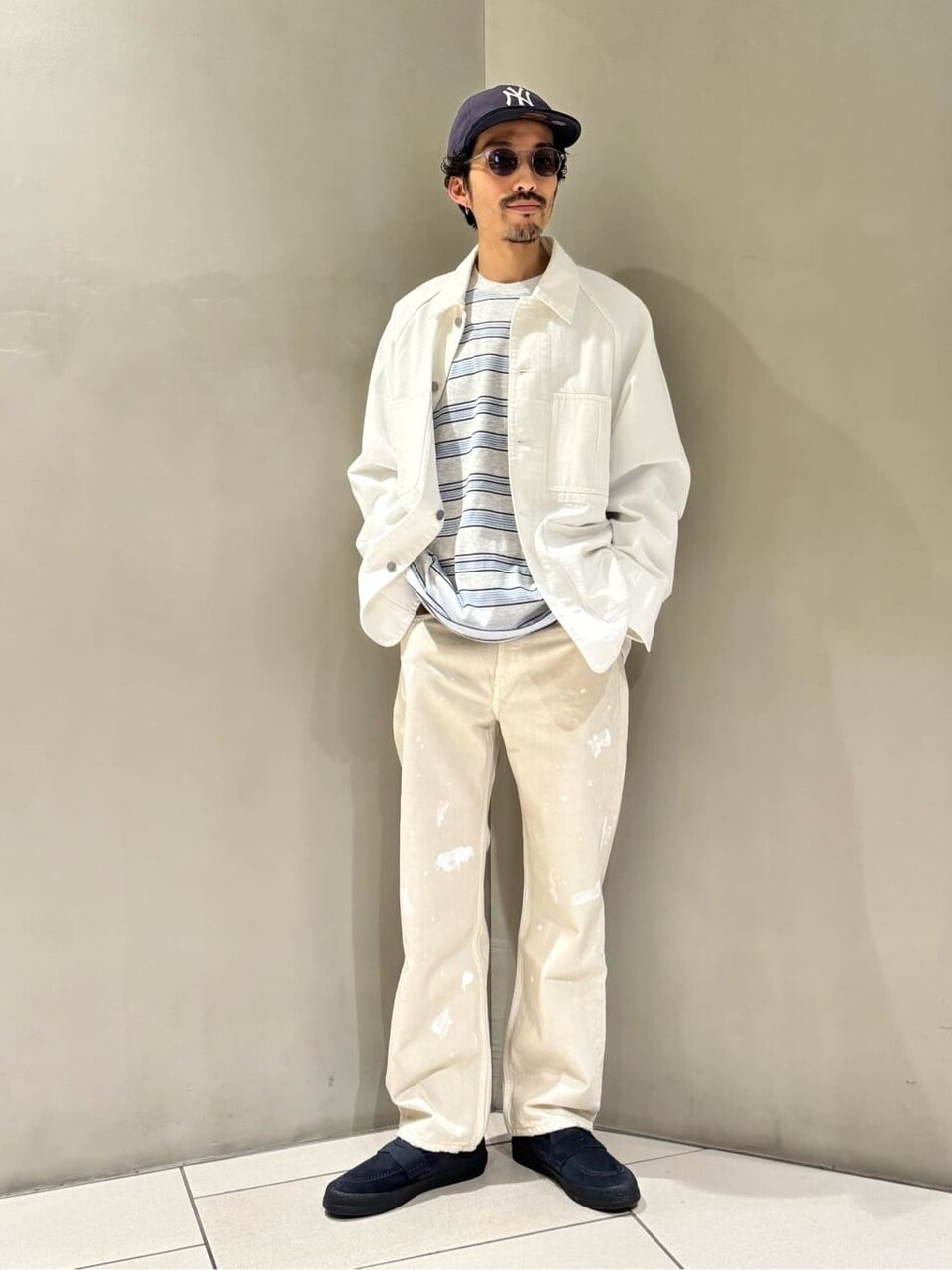 白のカバーオールとデニムを着た男性