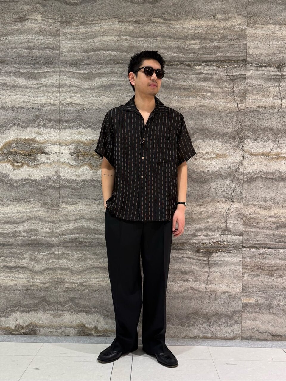 ストライプシャツとスラックスを着た男性