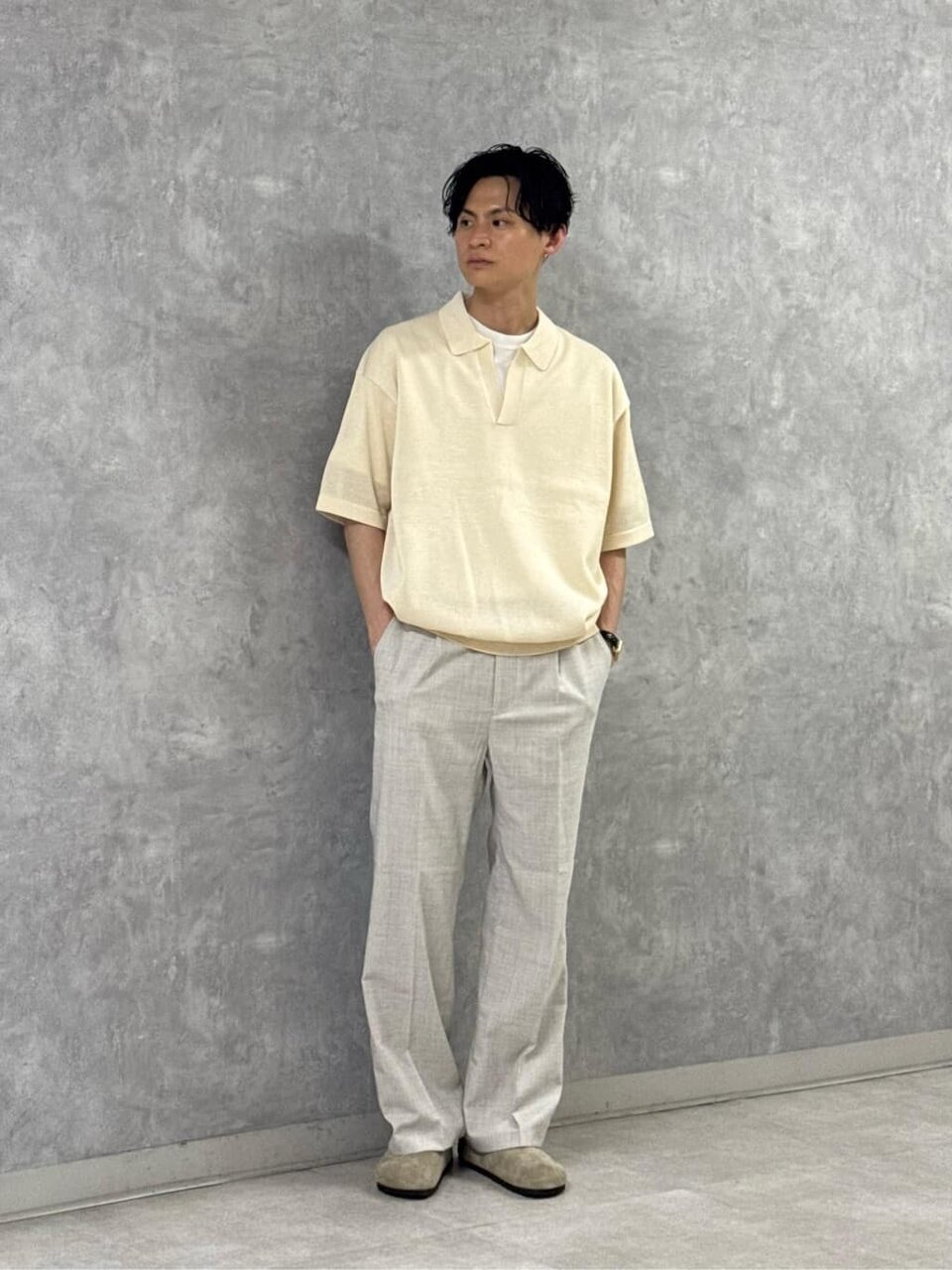 ニットポロとスラックスを着た男性