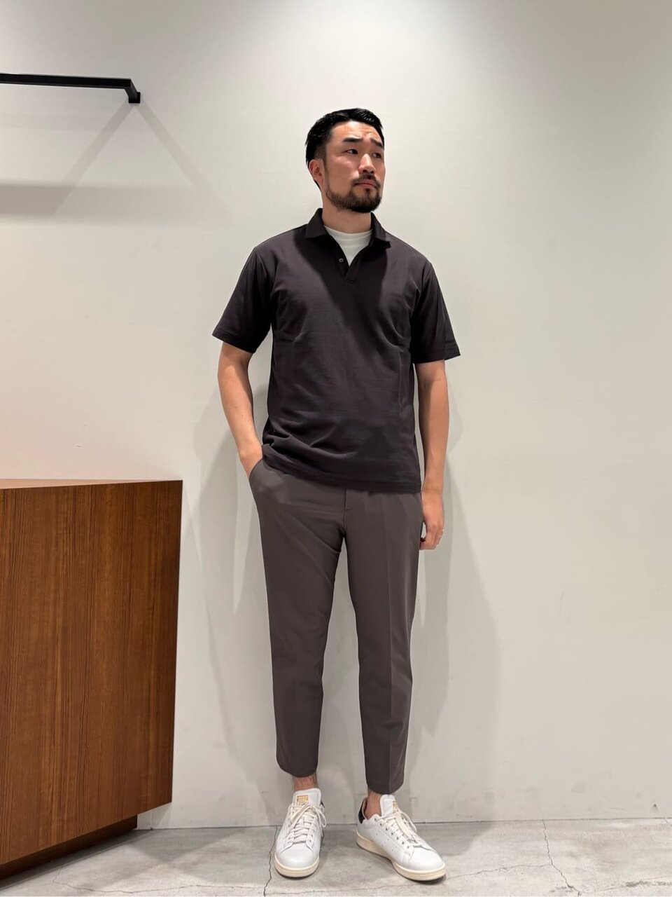 ポロシャツとテーパードパンツを着た男性