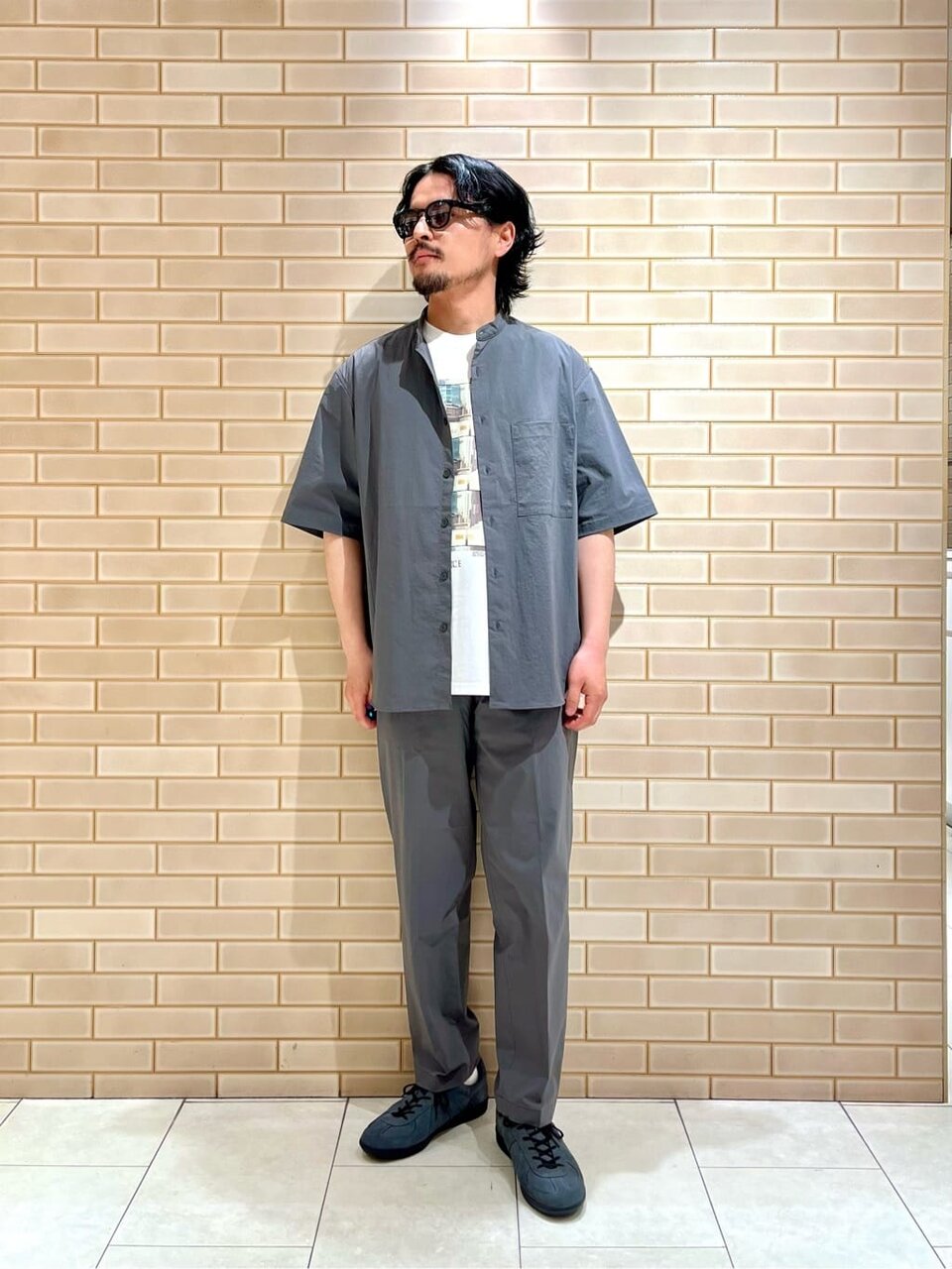 バンドカラーシャツのセットアップを着た男性