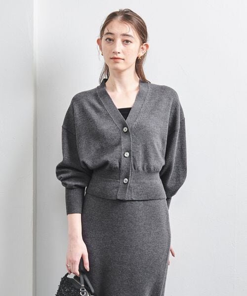 ドロップショルダーのカーディガンを着た女性
