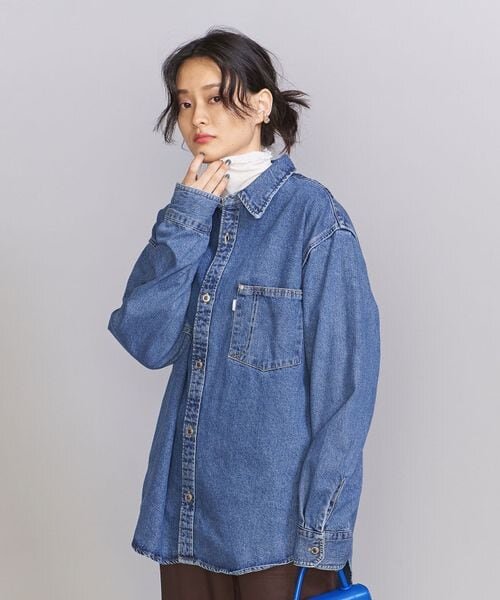 ビッグカラーのクロップド丈ニットを着た女性