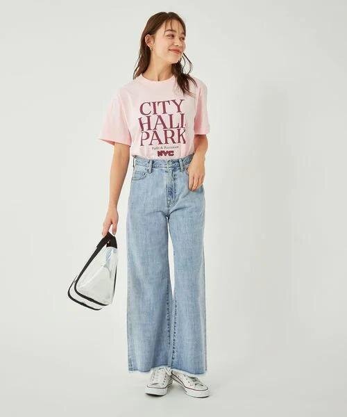 ピンクのTシャツとハイウエストデニムを着た女性