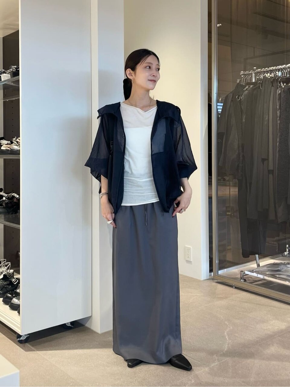 シアー素材のパーカーとスカートを着た女性