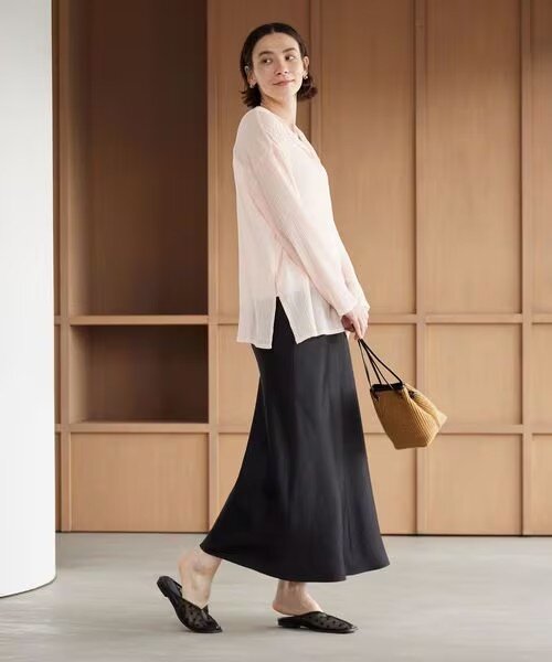 グリーンのノースリーブとマーメイドスカートを着用した女性