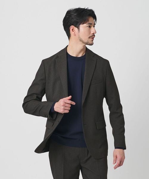 スーツにニットTシャツを着た男性