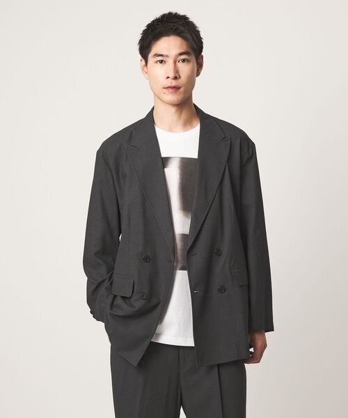 スーツにグラフィックTシャツを着ている男性