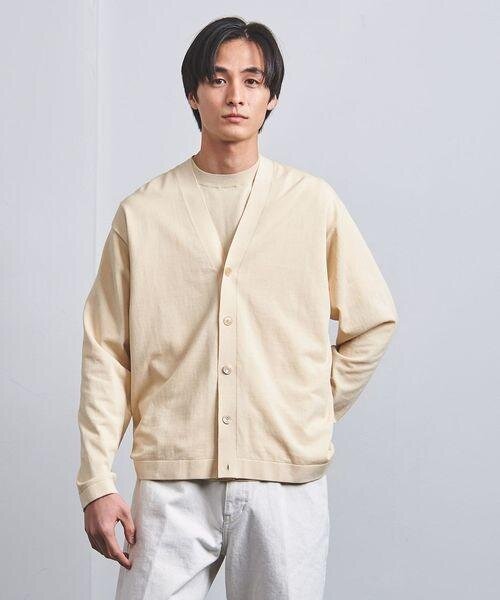 ナチュラルカラーのカーディガンを着用している男性