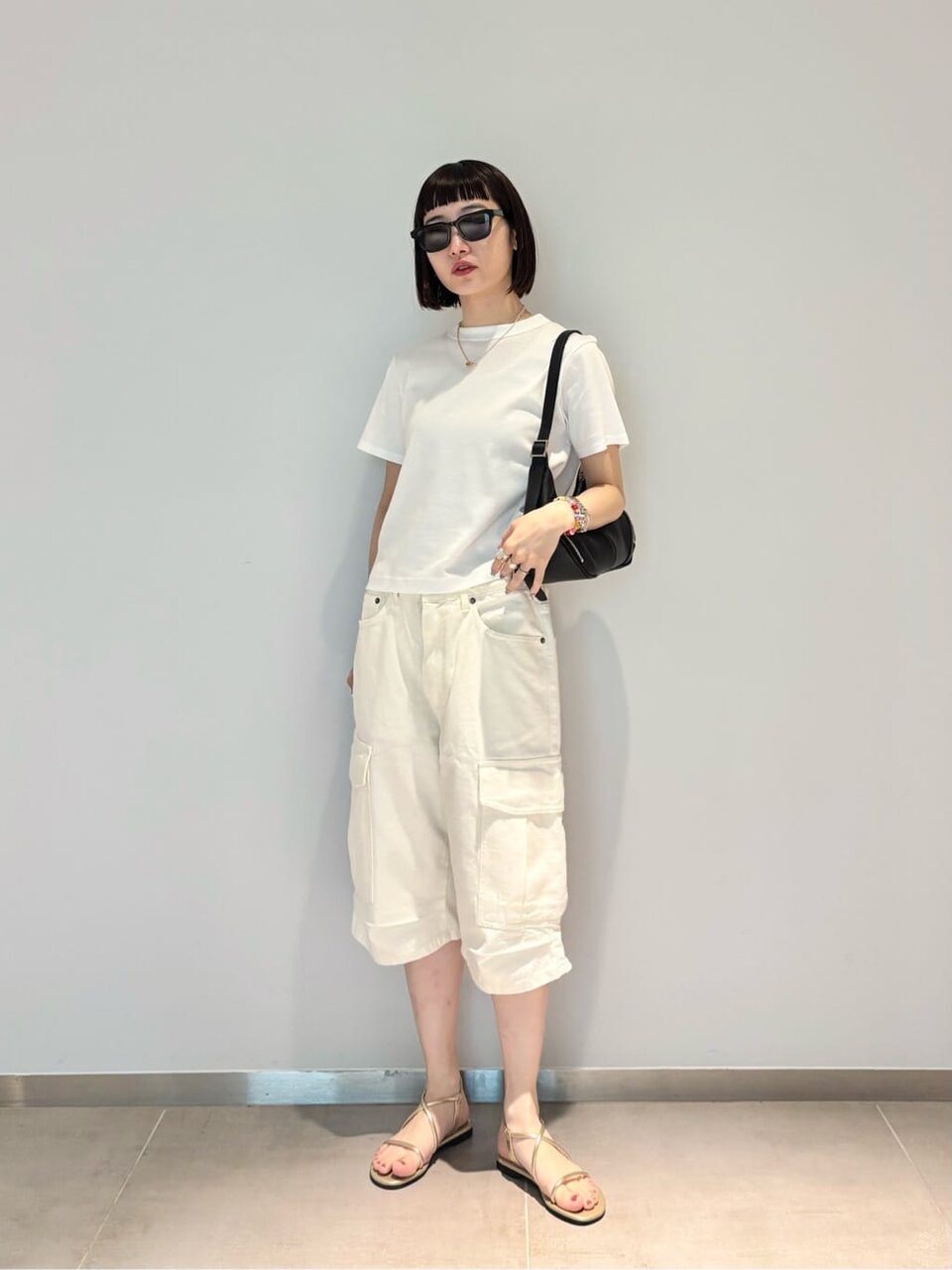 白Tシャツとハーフカーゴパンツを着た女性