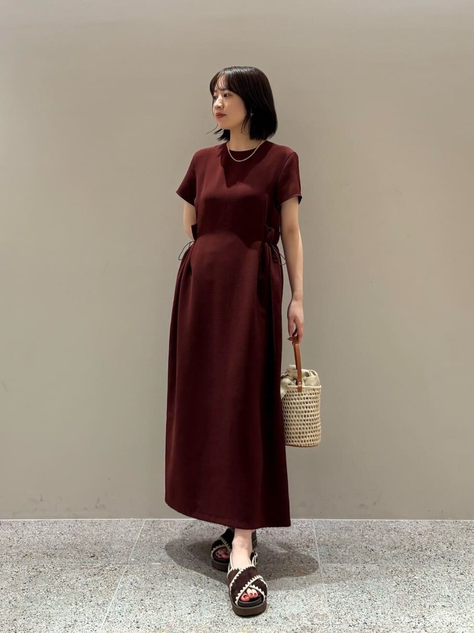 ワインカラーのワンピースを着た女性