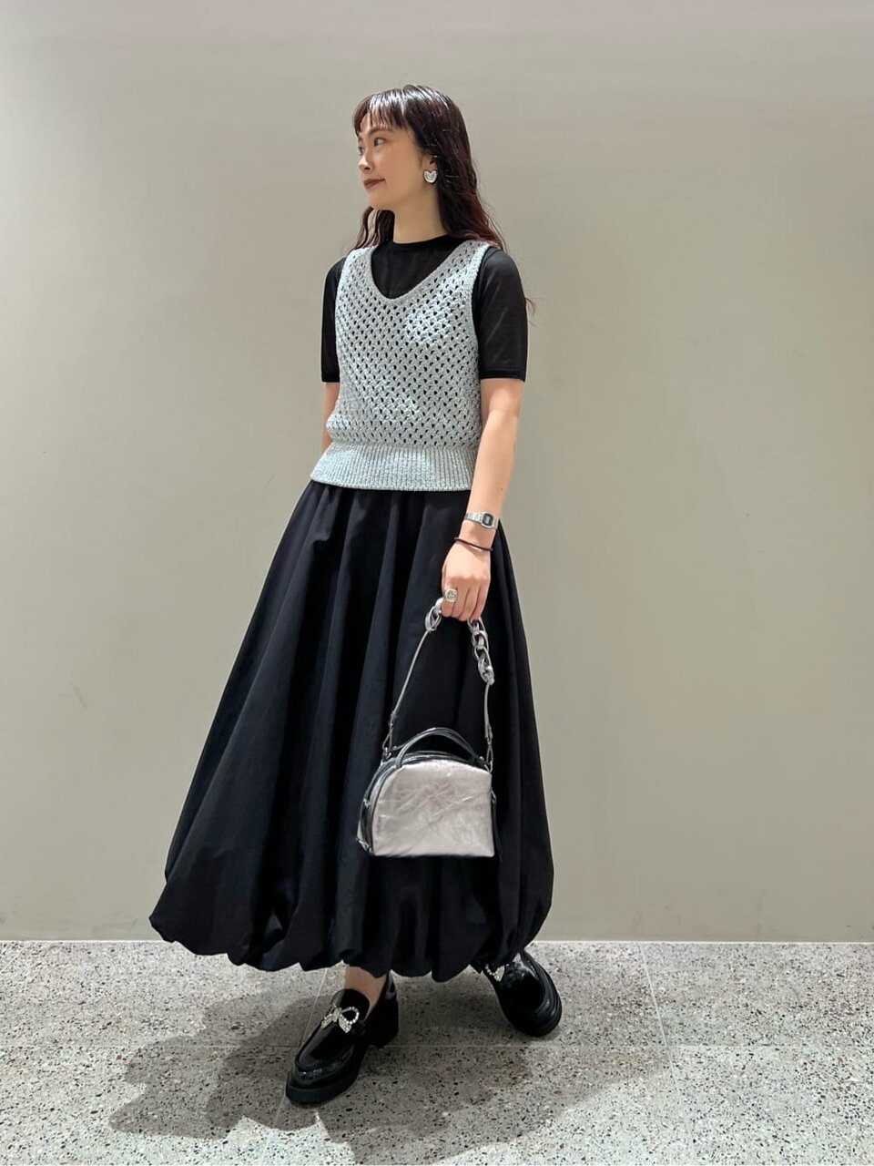 ベージュのトップス×黒スカートのコーデ