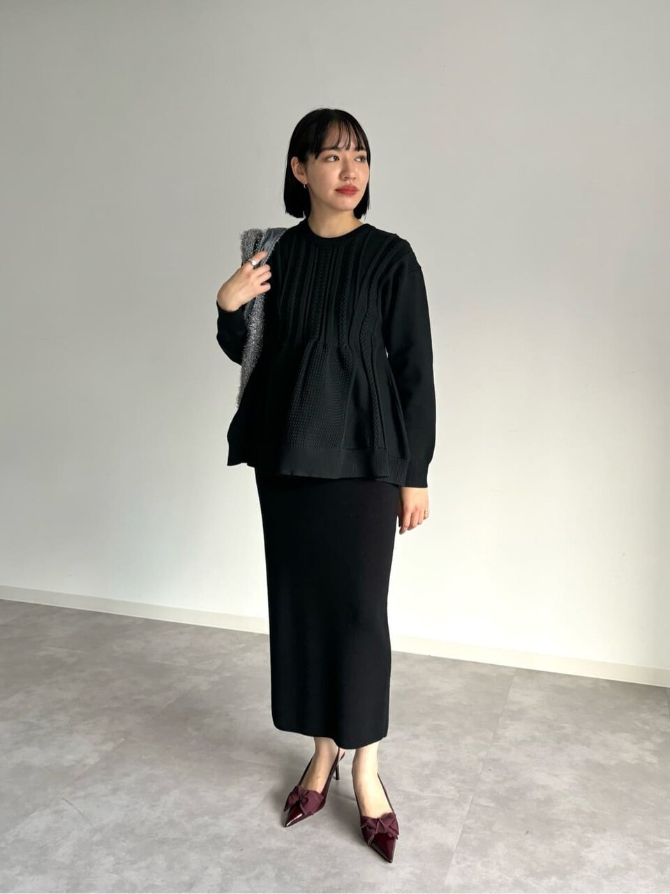 ブルゾンと黒スカートを着用した女性