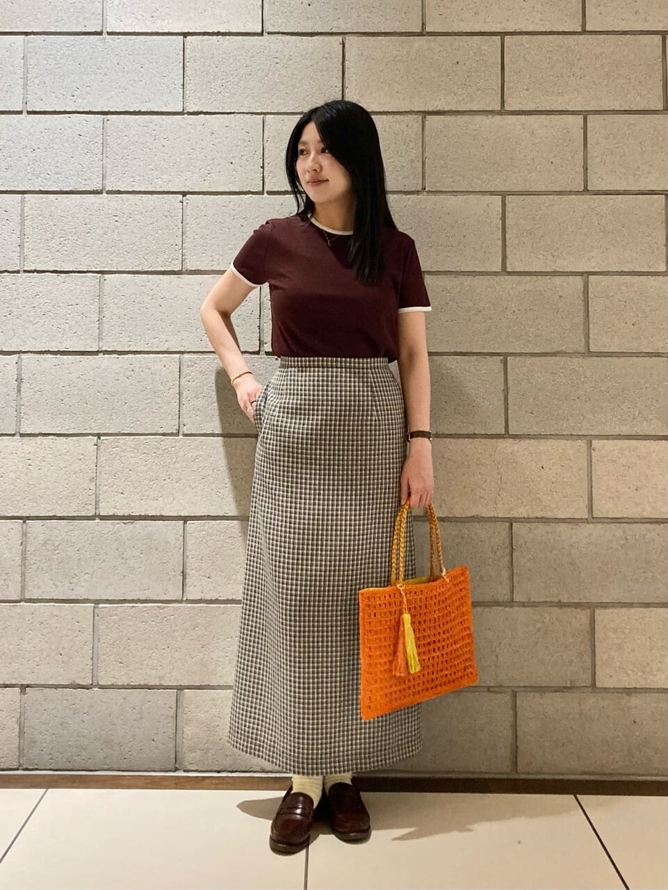 ブラウンのリンガーTシャツ×チェック柄のスカートのコーデ