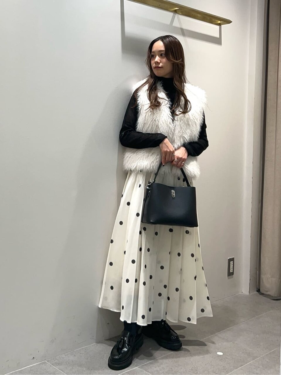 フェイクファーベストを羽織った女性