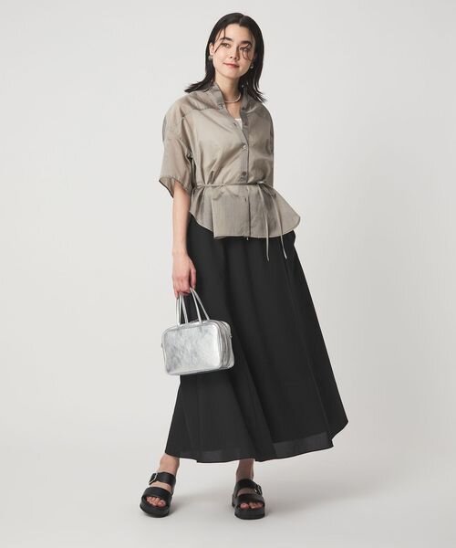 ベージュのトップス×黒スカートのコーデ