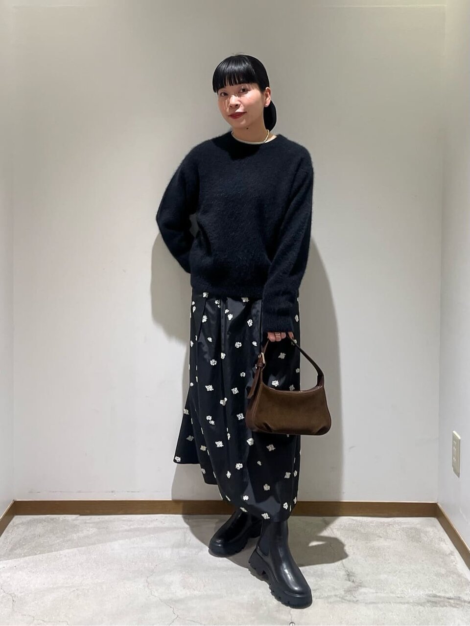 ファーニットと花柄スカートを着た女性