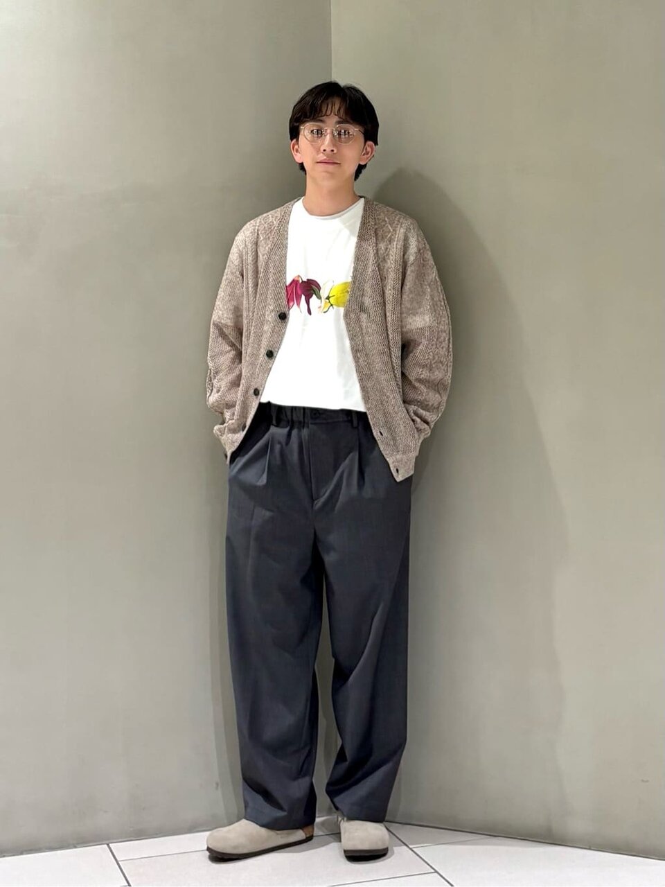 グラフィックTシャツとカーディガンを着た男性