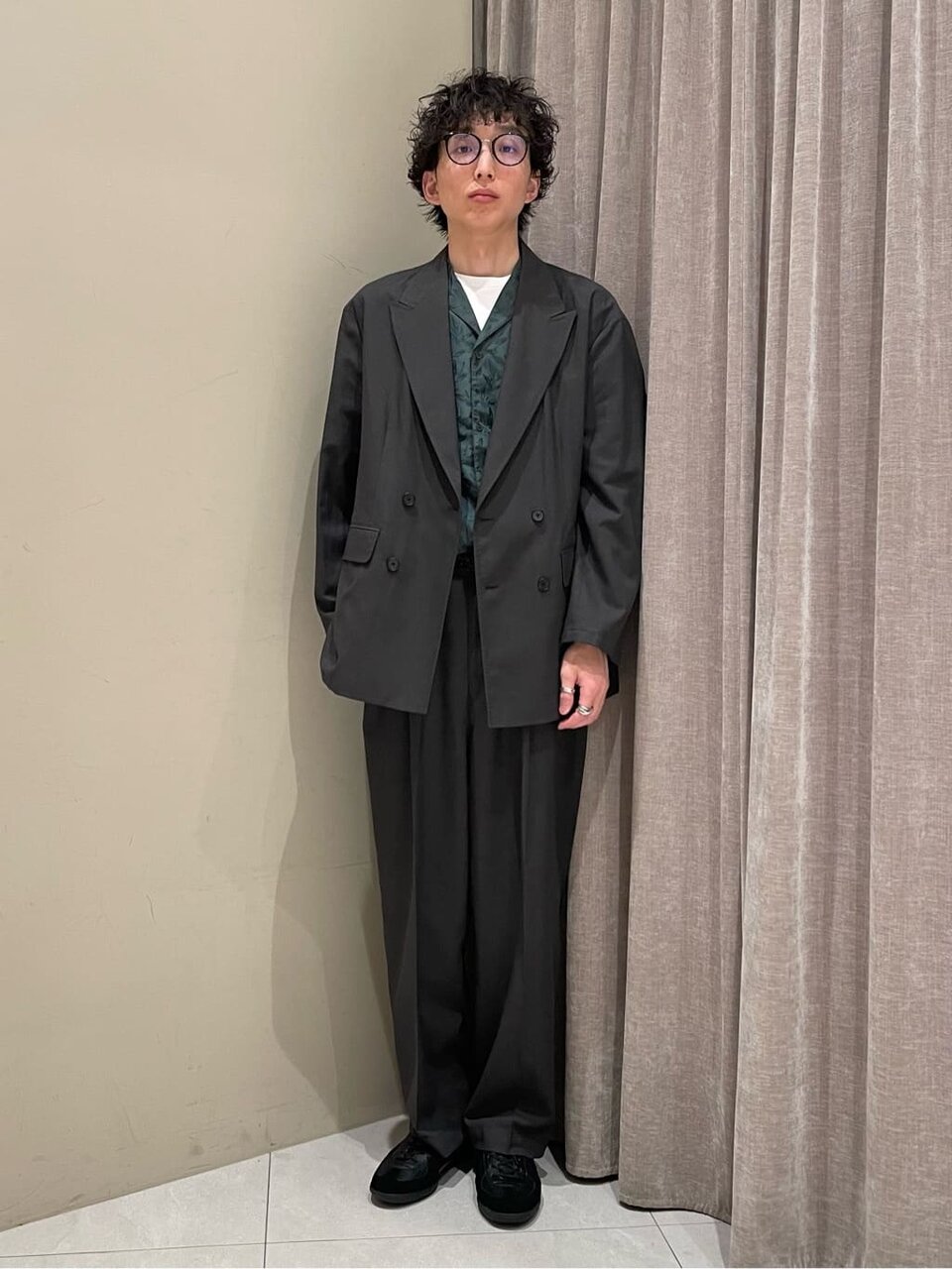 セットアップジャケットとオープンカラーシャツを着た男性