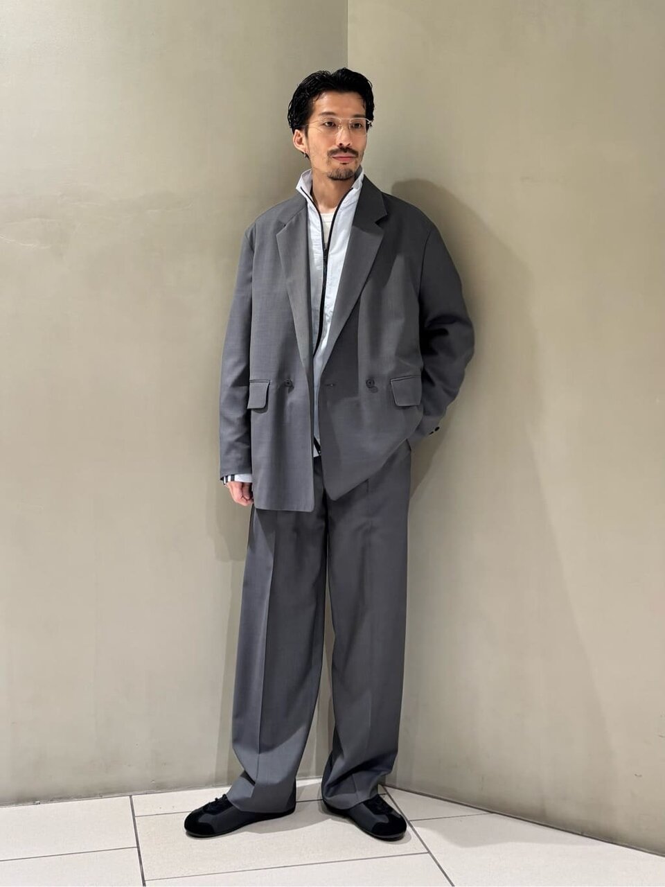 テーラードジャケットとフッドボールジャケットを着た男性