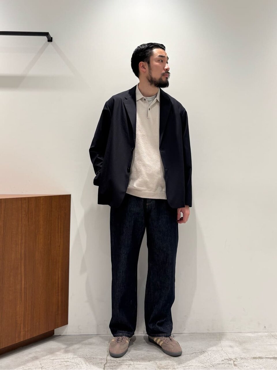 テーラードジャケットとニットポロを着た男性