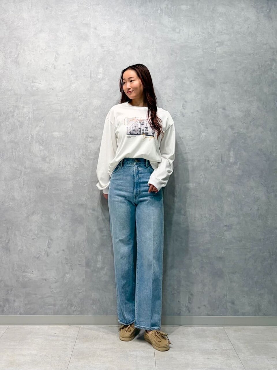 プリントTシャツとハイウエストデニムを着た女性