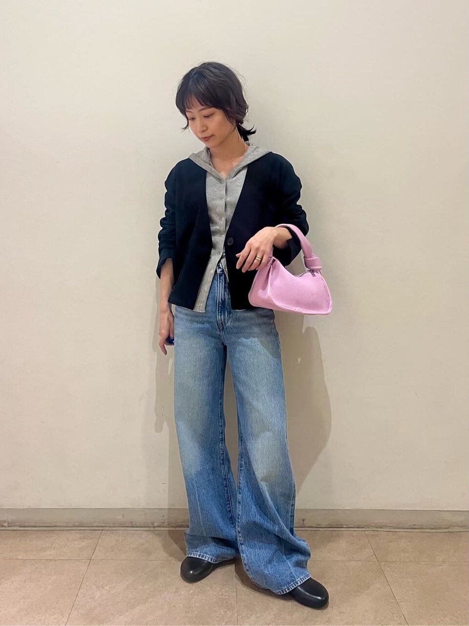 フード付きカーディガンとジャケットを着た女性