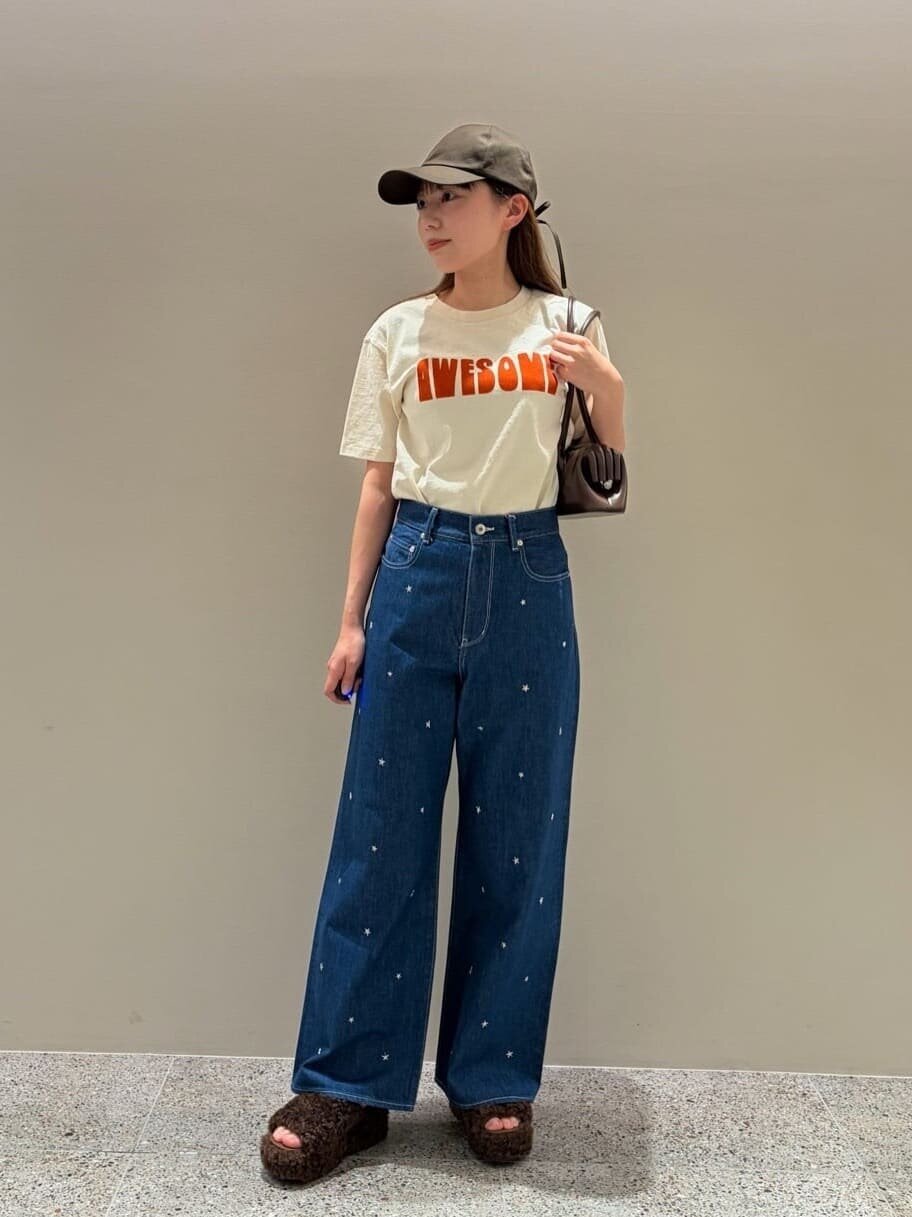 ロゴTシャツとハイウエストデニムを着た女性