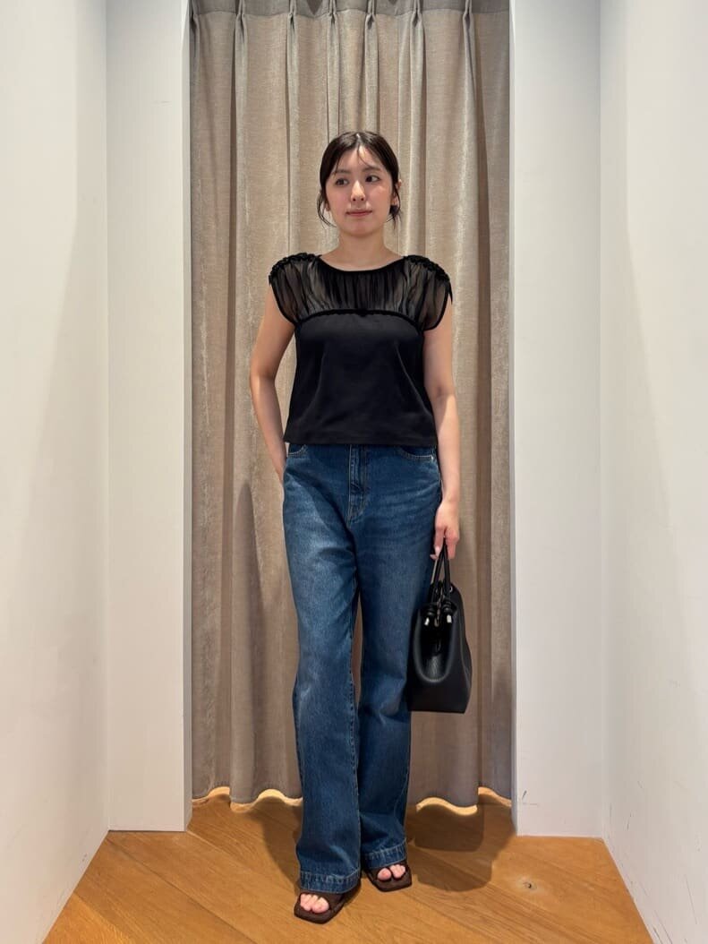 ブラックTシャツとハイウエストデニムを着た女性
