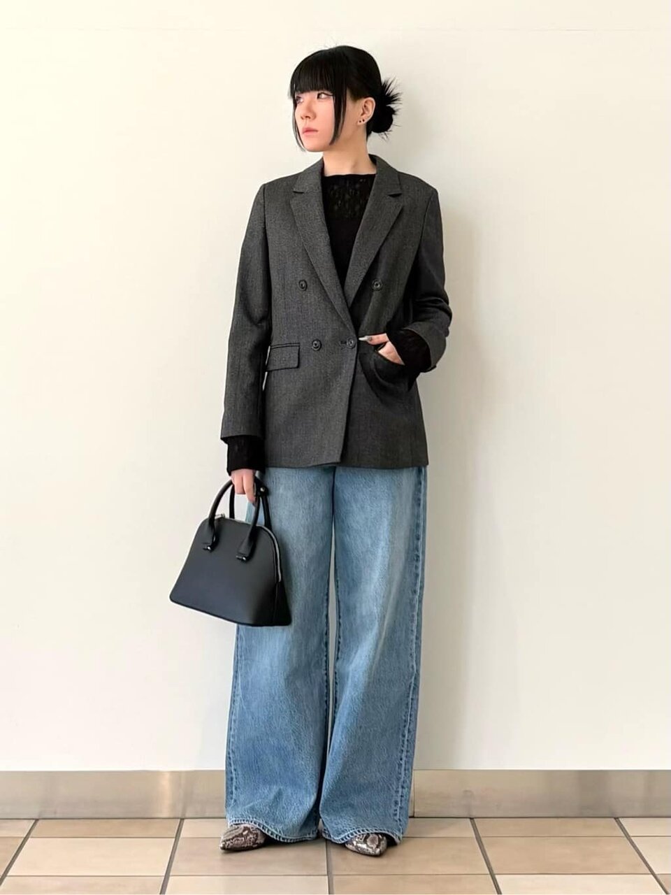ダブルジャケットとハイウエストデニムを着た女性