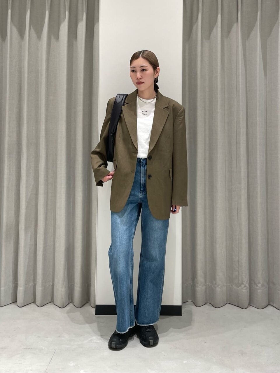 テーラードジャケットとハイウエストデニムを着た女性
