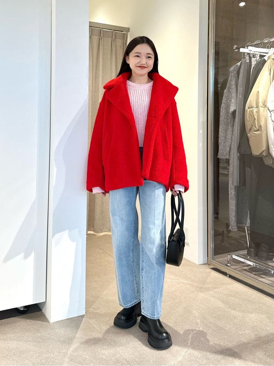 ボアジャケットとハイウエストデニムを着た女性