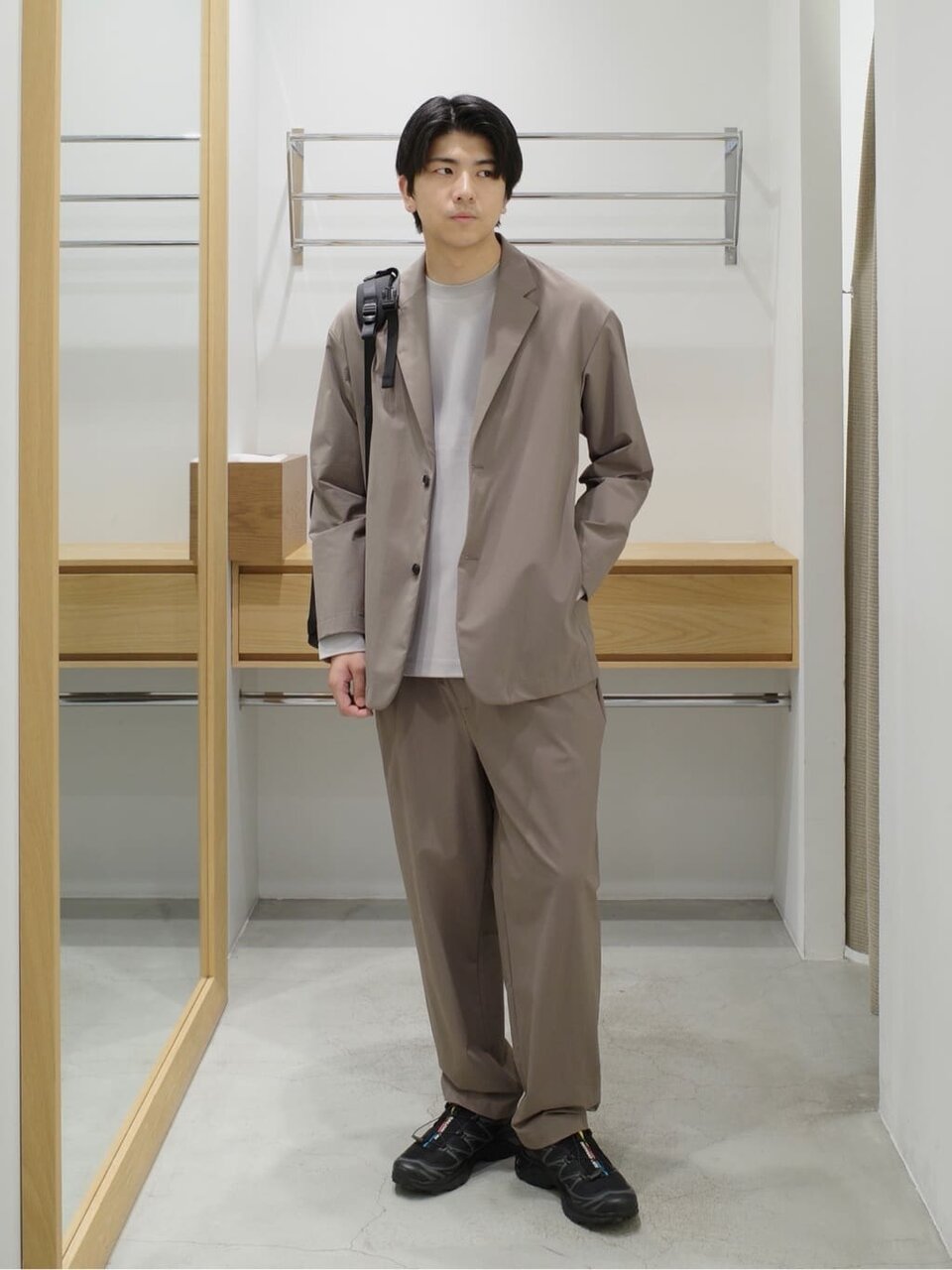 セットアップジャケットとイージーパンツを着た男性