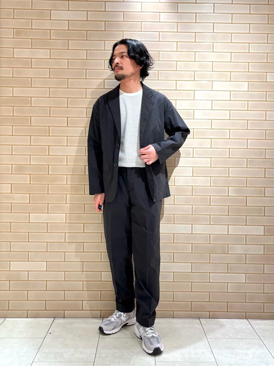 セットアップジャケットとイージーパンツを着た男性