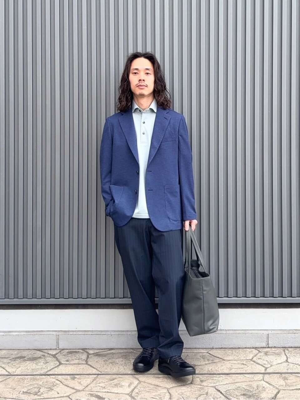 テーラードジャケットとイージーパンツを着た男性