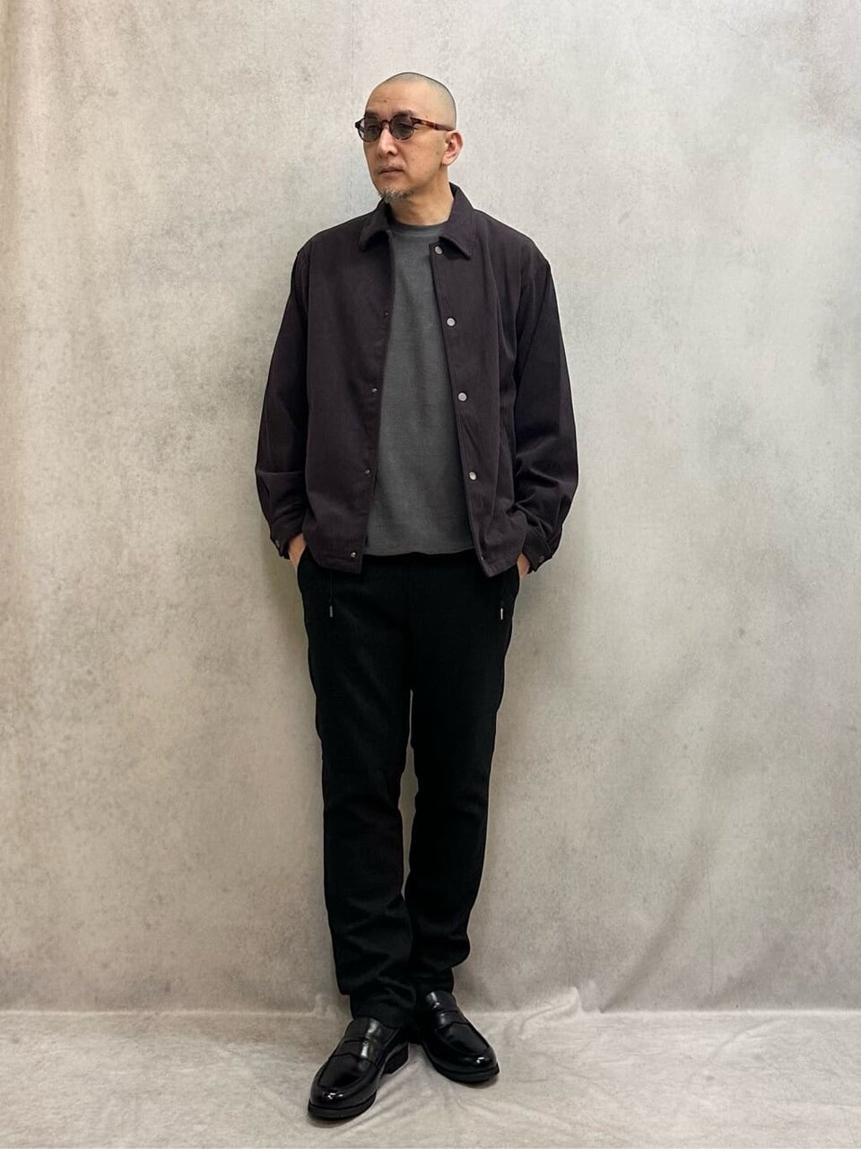 コーチジャケットとイージーパンツを着た男性