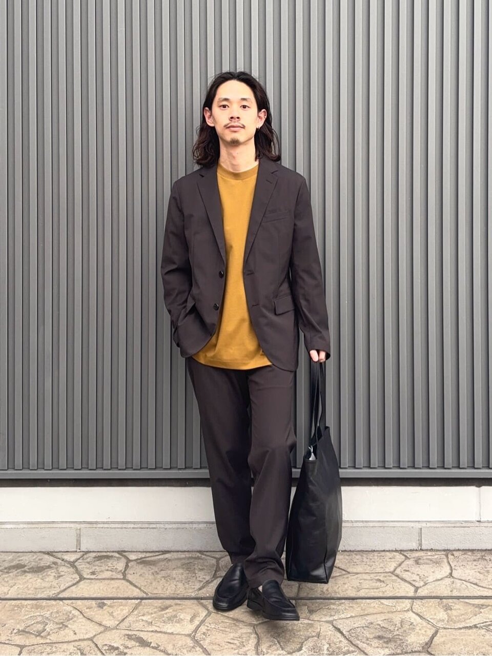 セットアップジャケットとイージーパンツを着た男性