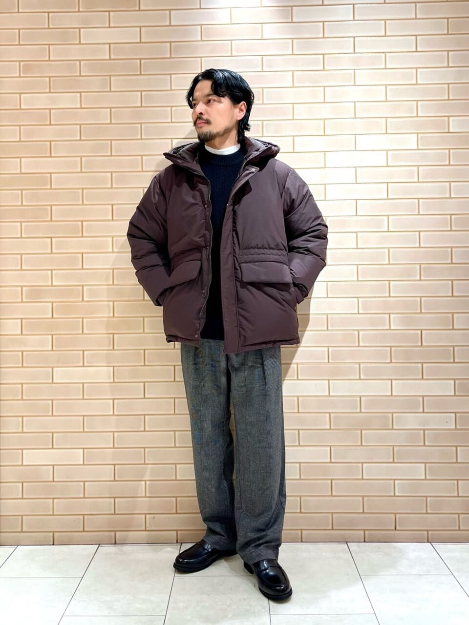 ダウンジャケットとイージーパンツを着た男性