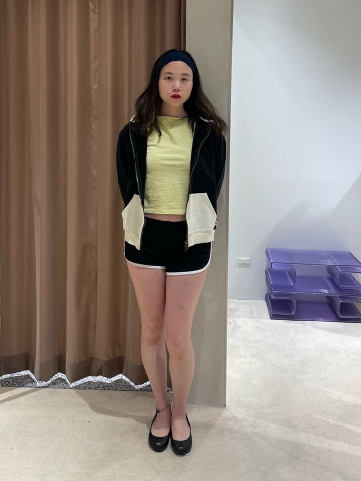 クロップドTシャツとショートパンツの女性