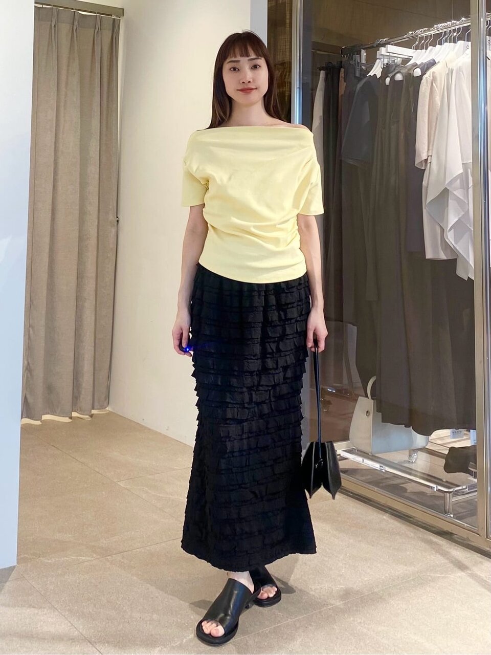 オフショルダートップスとフリルスカートを着た女性