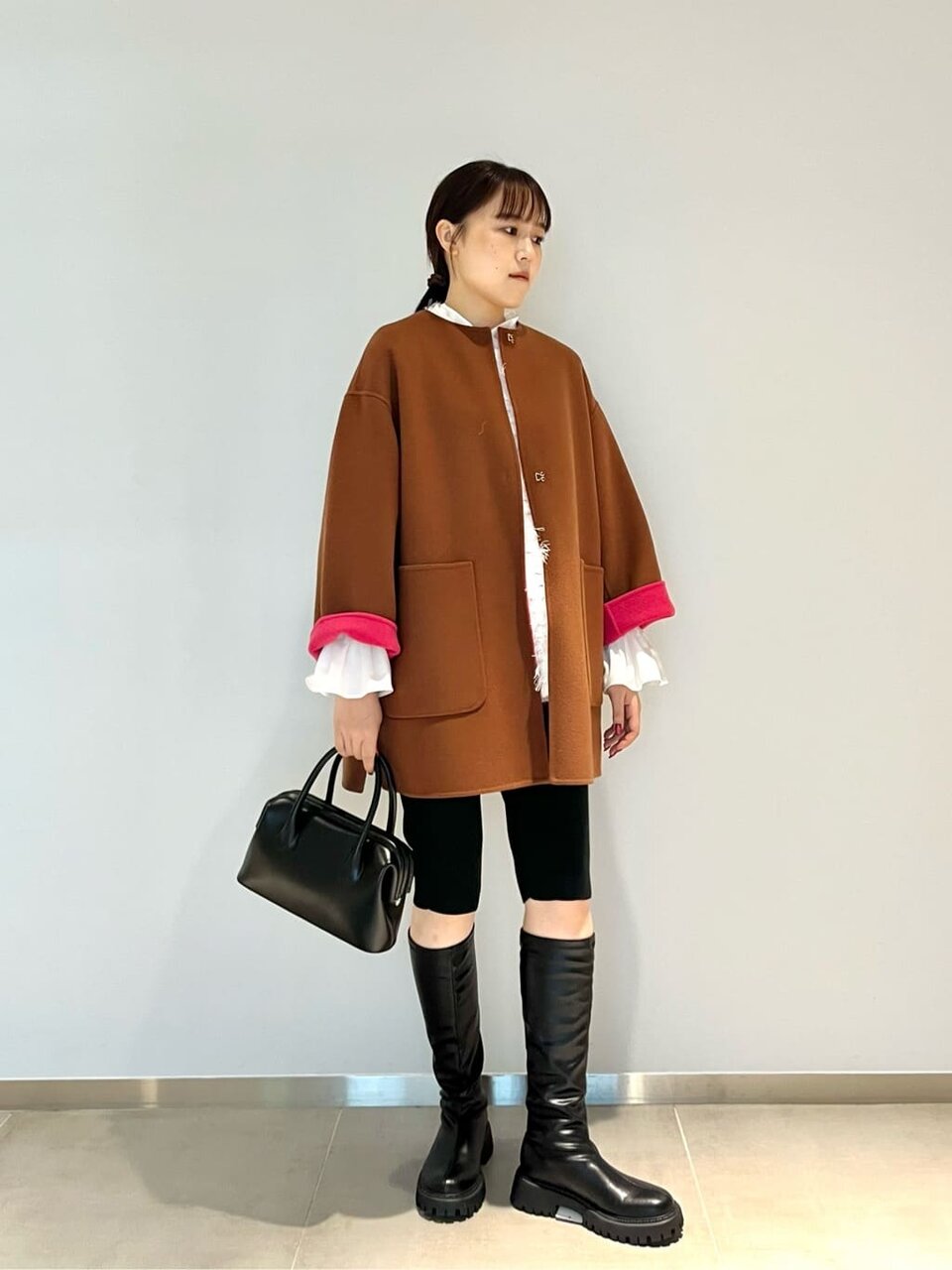 バイカラーコートとハーフパンツを着た女性