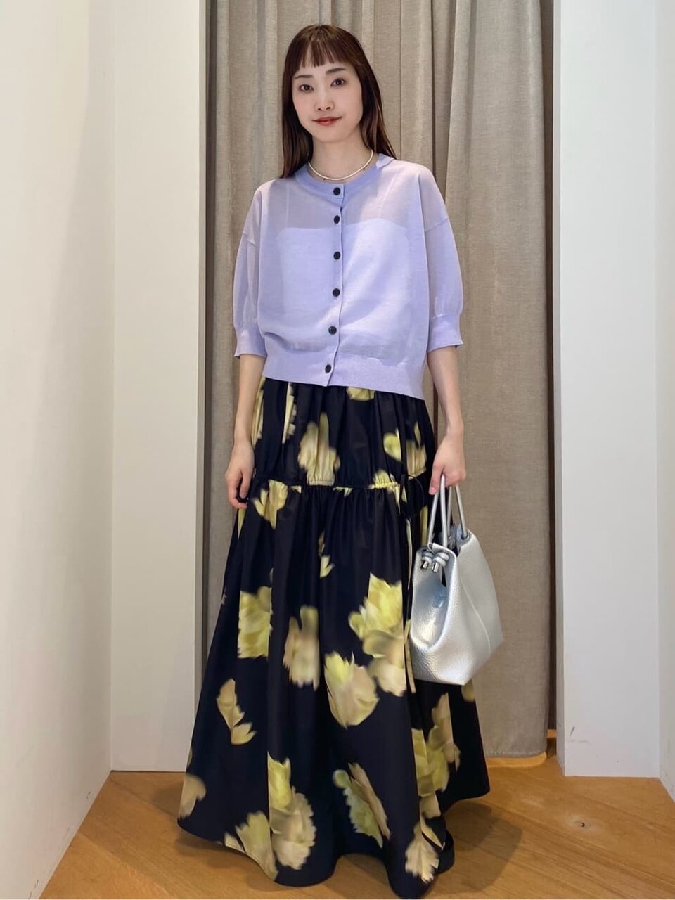 カーディガンと花柄スカートを着た女性