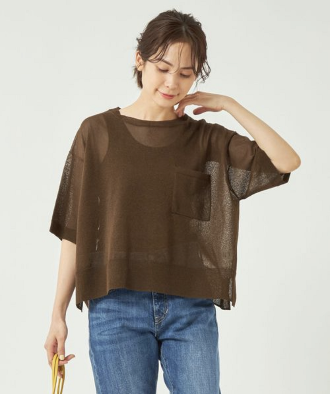 ブラウンのニットプルオーバーを着ている女性