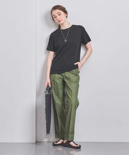 黒のTシャツと緑のパンツの女性