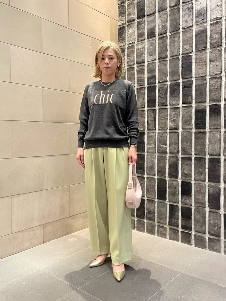 緑のテーパードパンツ×ロゴニットのコーデ