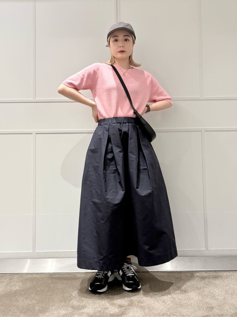 フレアスカートとキャップを身につけた女性