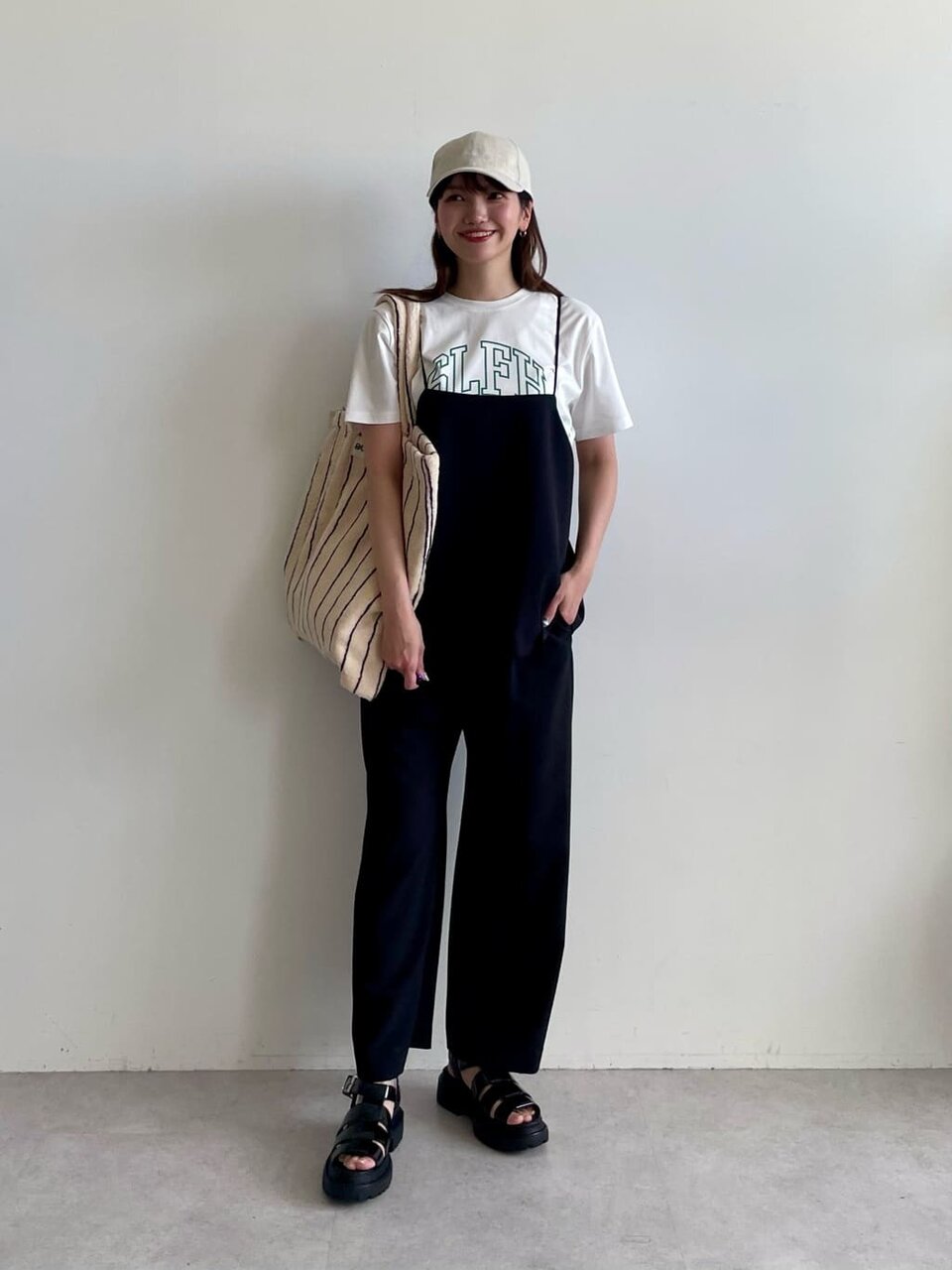 オールインワンとキャップを身につけた女性