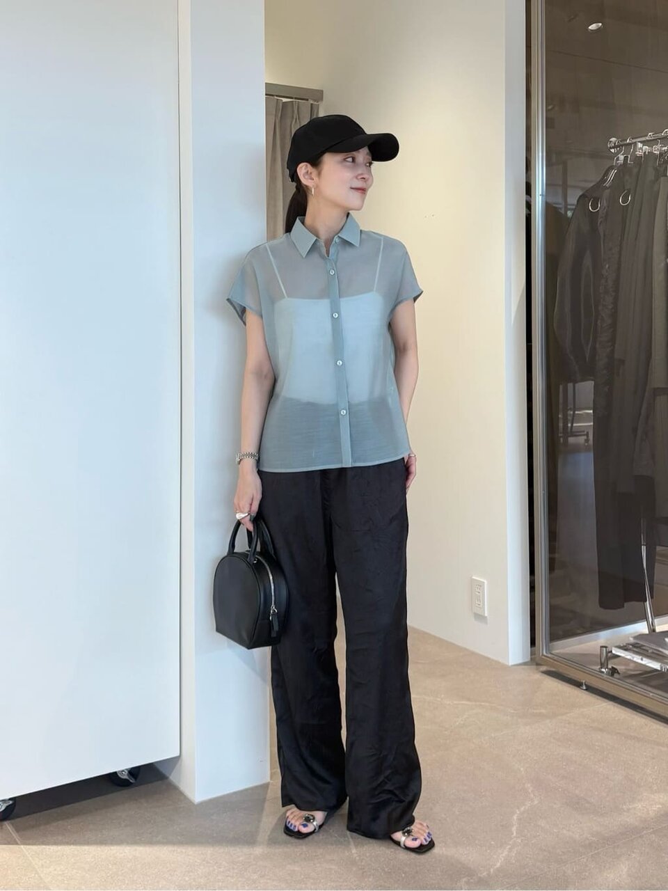 シースルーブラウスとキャップを身につけた女性