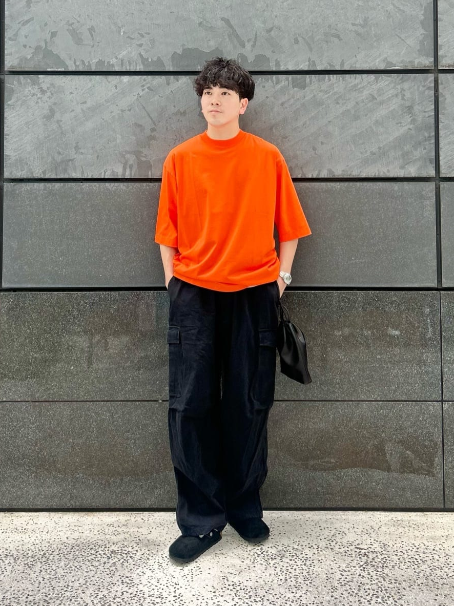 オレンジのＴシャツ×黒のドリルパンツのコーデ